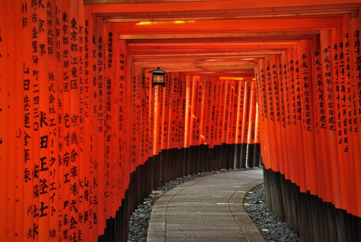 Corridor of red torii gates curving into the distance at Fushimi Inari Taisha, Kyoto, Japan