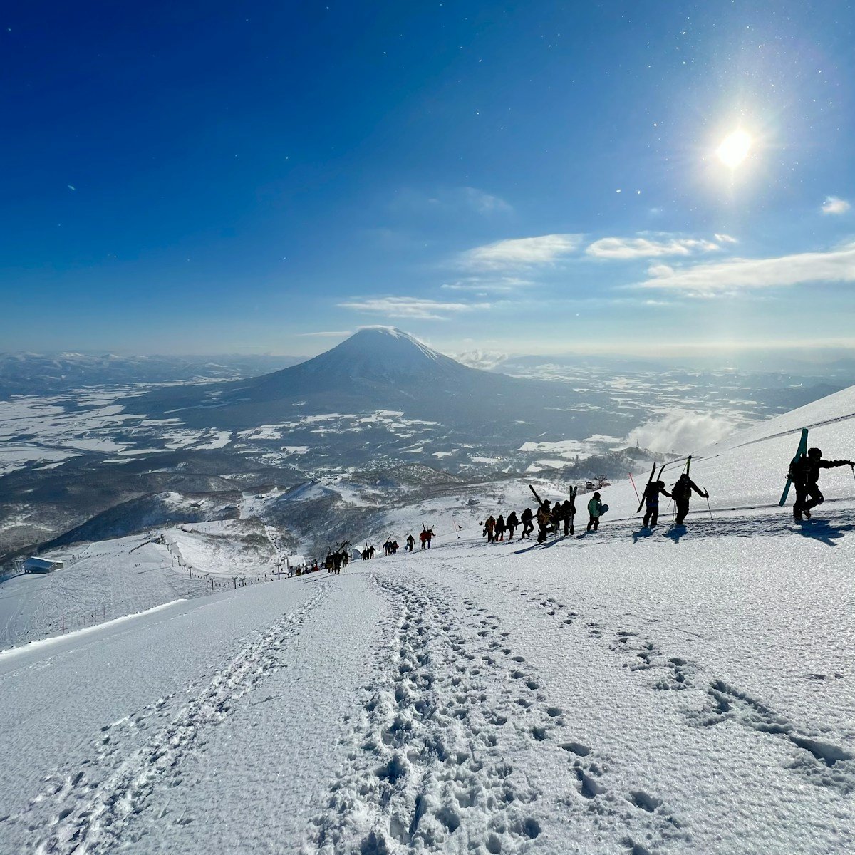 Skiers hiking up a snow covered slope at Niseko, Hokkaido Japan — Niseko vs Hakuba comparison