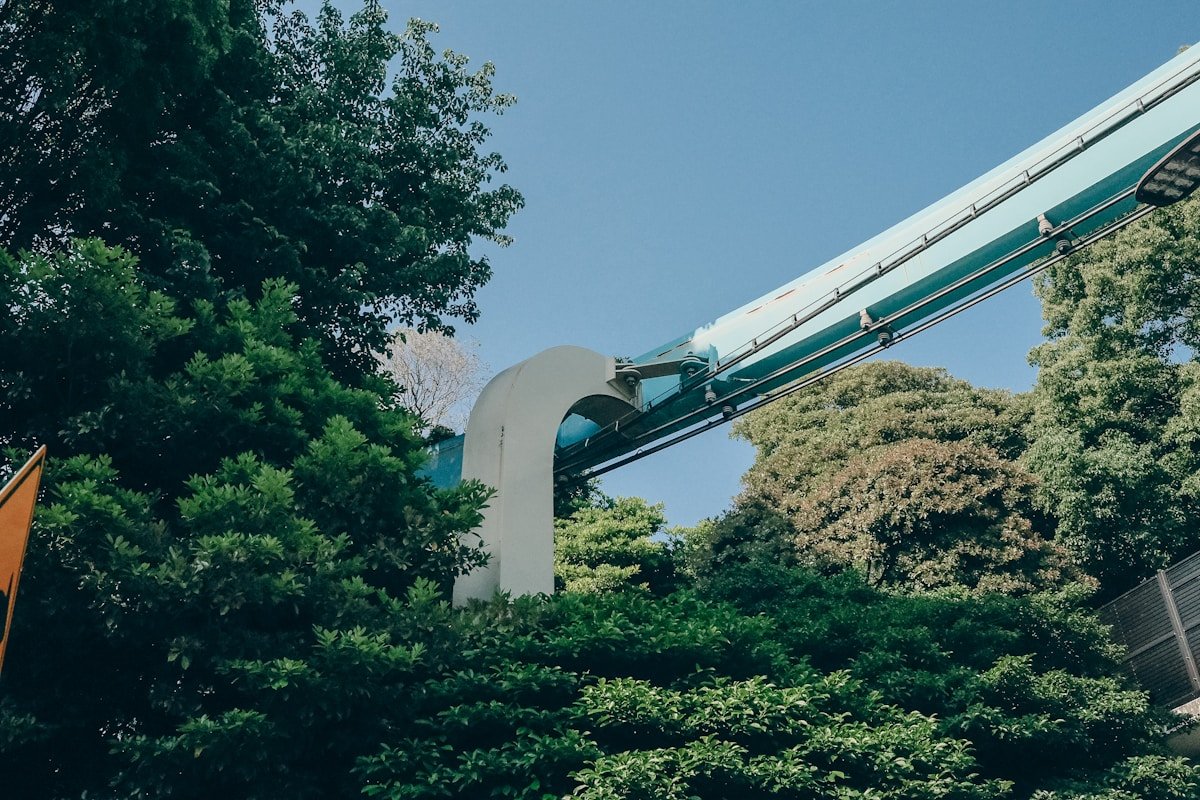 Amusement park ride winding through tree canopy at a Japanese theme park — PokéPark Kanto, Kanto region, Japan