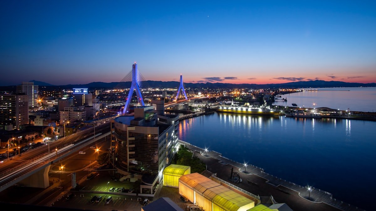 Aomori city at night with illuminated cable-stayed bridge and bay, Aomori Japan