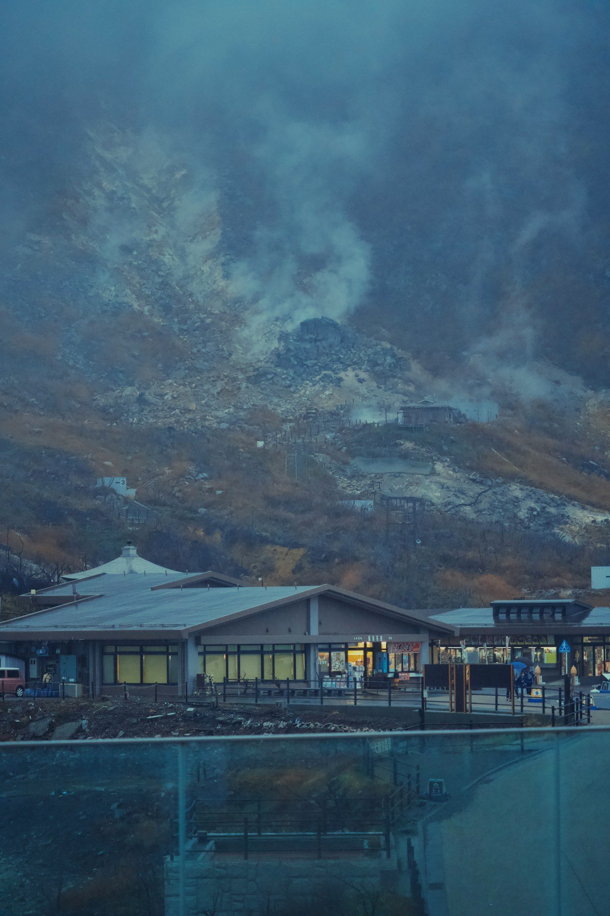 Owakudani geothermal valley with steam vents and visitor centre at dusk, Hakone, Japan