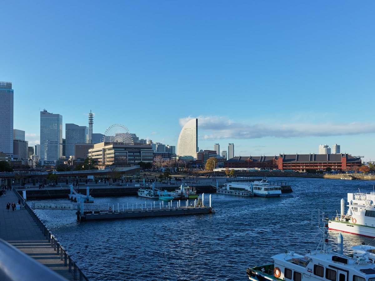 Yokohama harbor skyline with ferris wheel and boats in the foreground, Japan