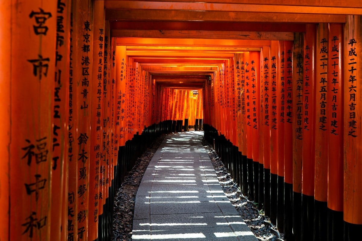 Tunnel of vermilion torii gates stretching into the distance - Fushimi Inari Taisha, Kyoto Japan