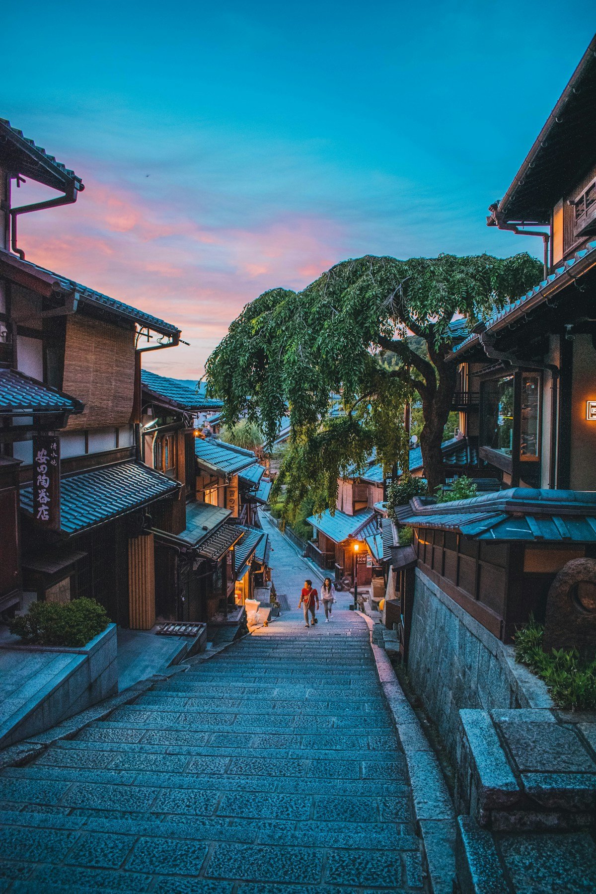 Traditional wooden machiya townhouses lining a cobblestone street at dusk - Higashiyama district, Kyoto