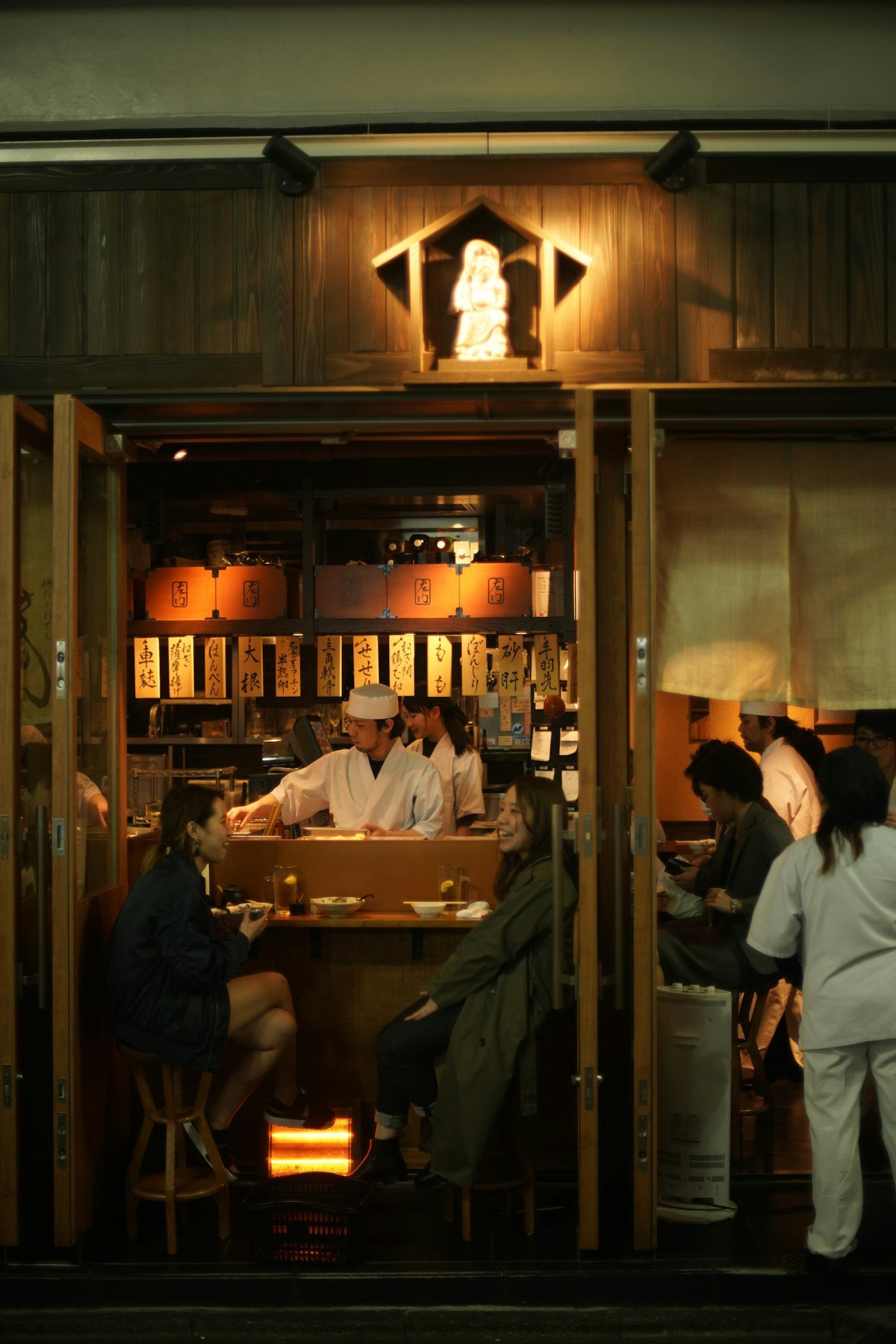 People sitting at a table inside a Japanese restaurant in Matsuyama