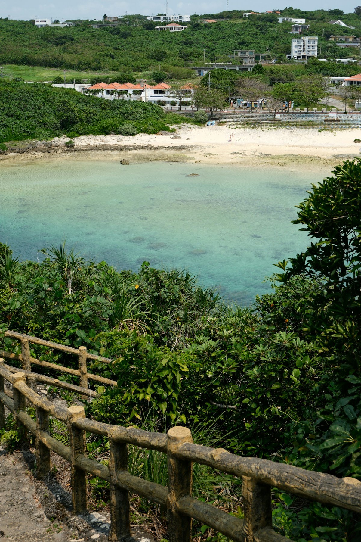 Wooden stairway leading down to a turquoise cove on the Okinawa coast, Japan