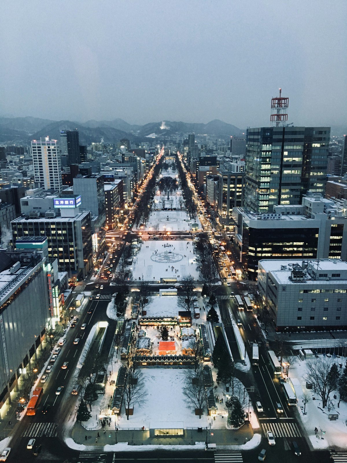 Sapporo tram running through snow-covered streets at night