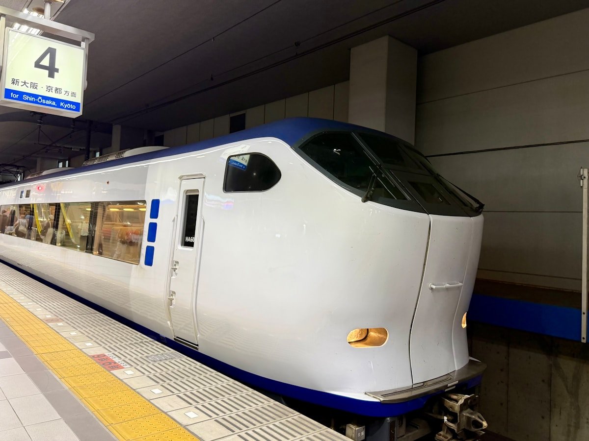 Modern white and blue train at a station platform near Kansai airport, Japan