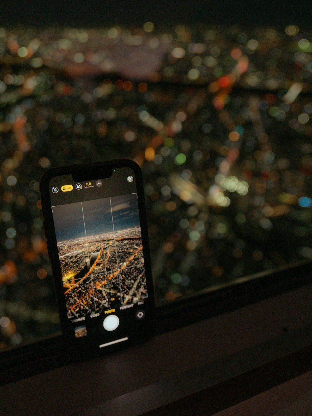 Smartphone photographing Tokyo city lights at night
