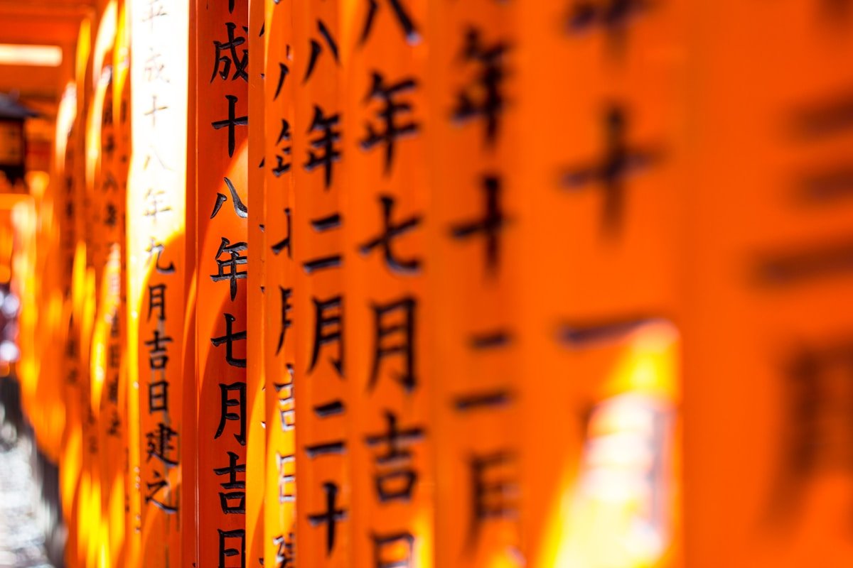 Kanji characters inscribed on orange torii gates at Fushimi Inari Shrine, Kyoto