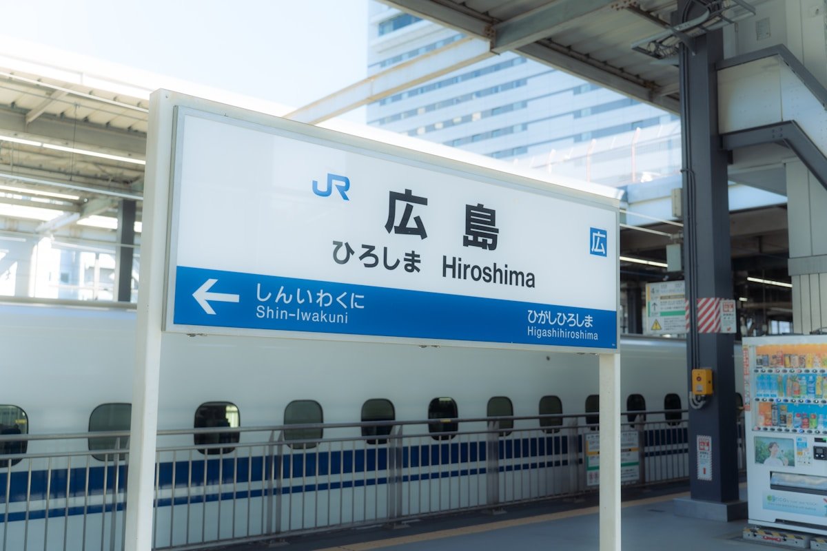 Hiroshima station sign with a bullet train — Japan Rail Pass guide