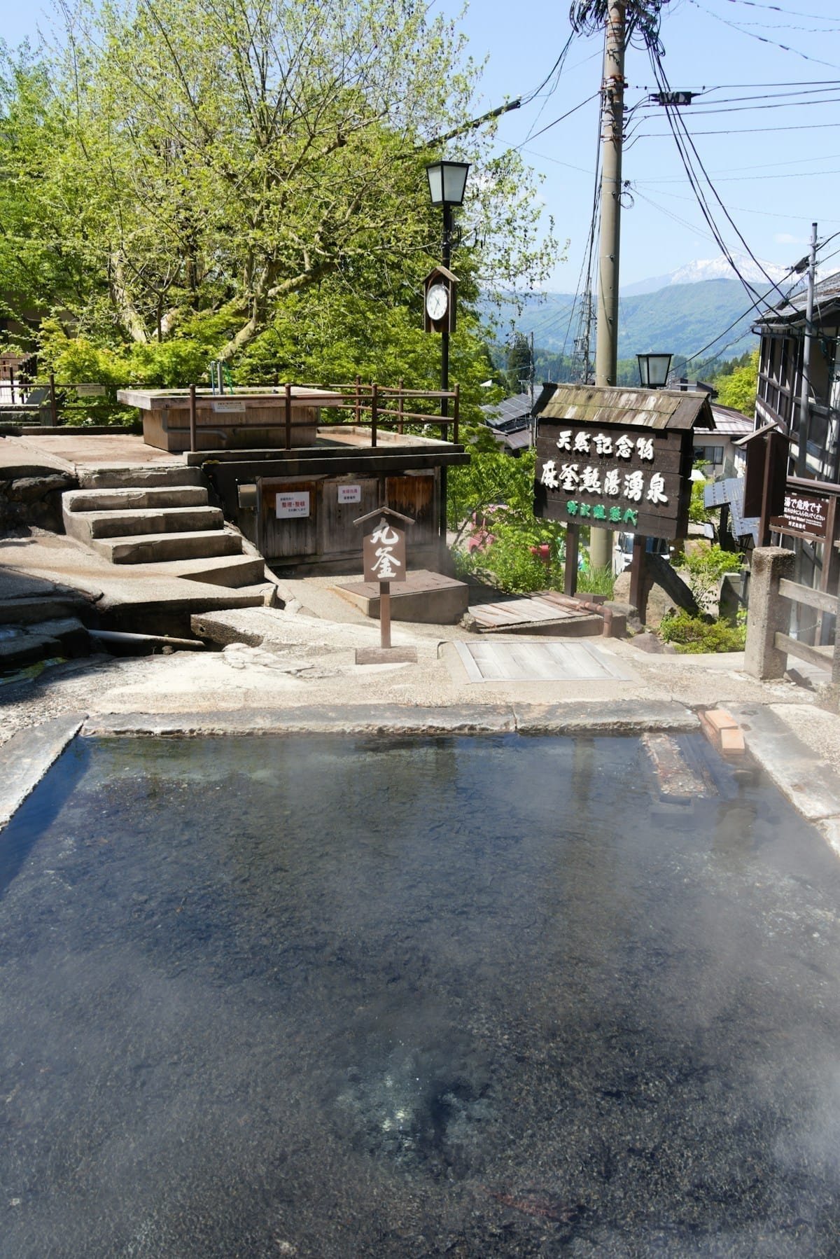 Outdoor hot spring with steam rising at a traditional onsen in Nozawa Onsen, Nagano, Japan