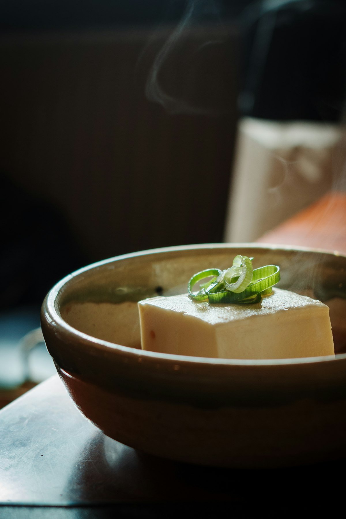 Steaming block of silken tofu in a traditional Japanese ceramic bowl, Kyoto