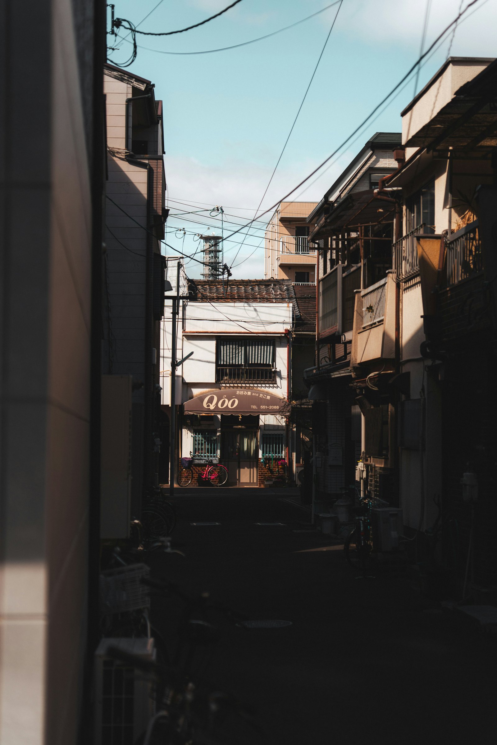 Ruelle urbaine étroite avec bâtiments et câbles électriques aériens à Osaka, Japon